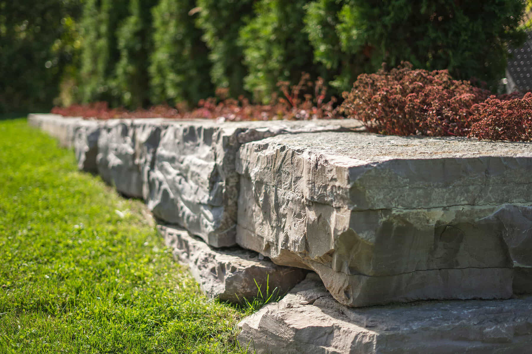 Landscape work with slab rocks and green grass