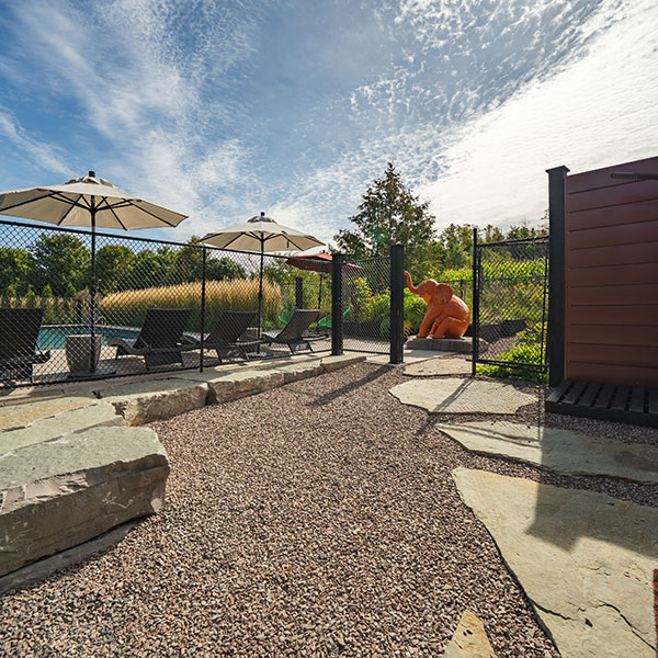 Landscaped outdoor patio with pea stone gravel and large slab rocks